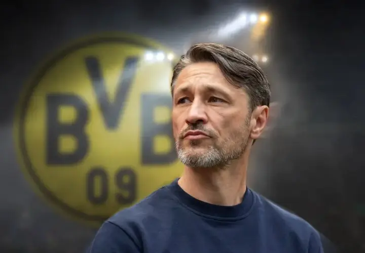 Twarz trenera Borussii Dortmund, z charakterystycznym logo klubu w tle.