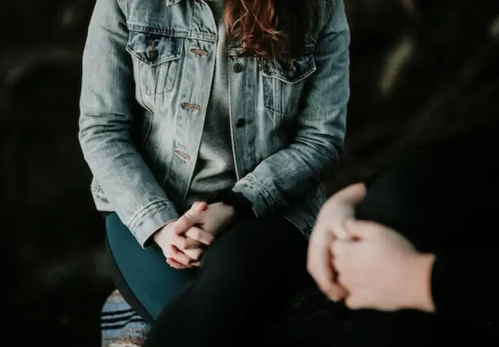 Due persone si tengono per mano, una con una giacca di jeans. Potrebbe essere un momento di conforto per chi soffre di paura del sangue, nome comune per l'emofobia.