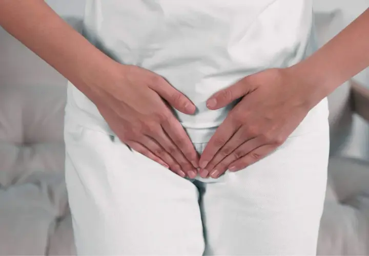 Mani che coprono l'area pelvica, suggerendo preoccupazione per ureaplasma parvum in gravidanza.