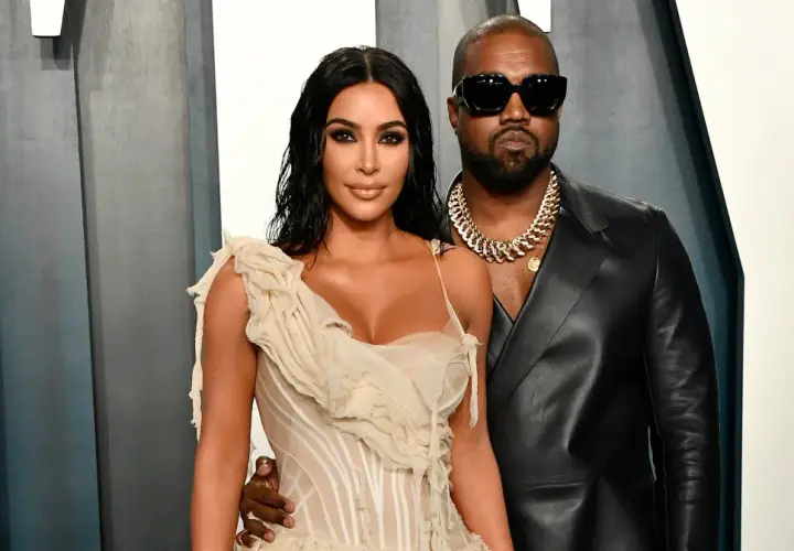 Kim Kardashian i jej mąż, Kanye West, pozują do zdjęć w eleganckich strojach.