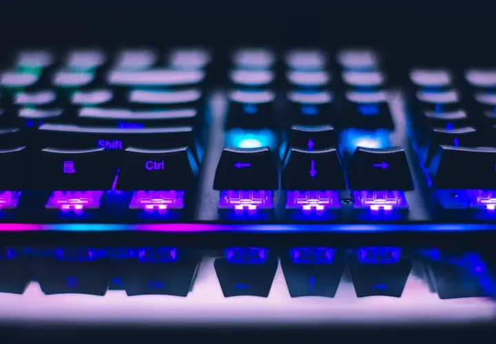 Klawiatura gamingowa z fioletowym i niebieskim podświetleniem. Idealna do gry w Fortnite, spełniając wszystkie wymagania sprzętowe.