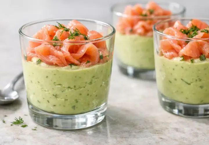 Verrine avocat saumon : une couche crémeuse d'avocat et d'herbes surmontée de fines tranches de saumon fumé, garnie d'aneth.