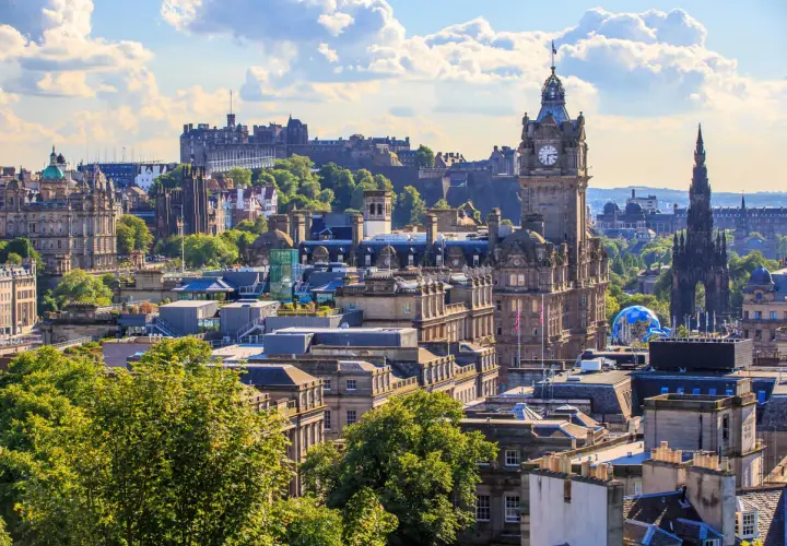 Edinburghs Skyline mit Schloss und Uhrenturm. Die beste Reisezeit für diese Aussicht ist im Sommer, wenn die Bäume grün sind.