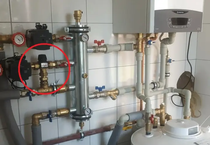 Czerwone kółko zaznacza zawór termostatyczny, kluczowy element systemu grzewczego, który reguluje temperaturę.