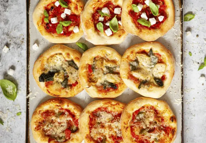 Mini pizze z mozzarellą, bazylią, pomidorami, karczochami i szpinakiem. Wiele opcji, co można dać na pizzę!