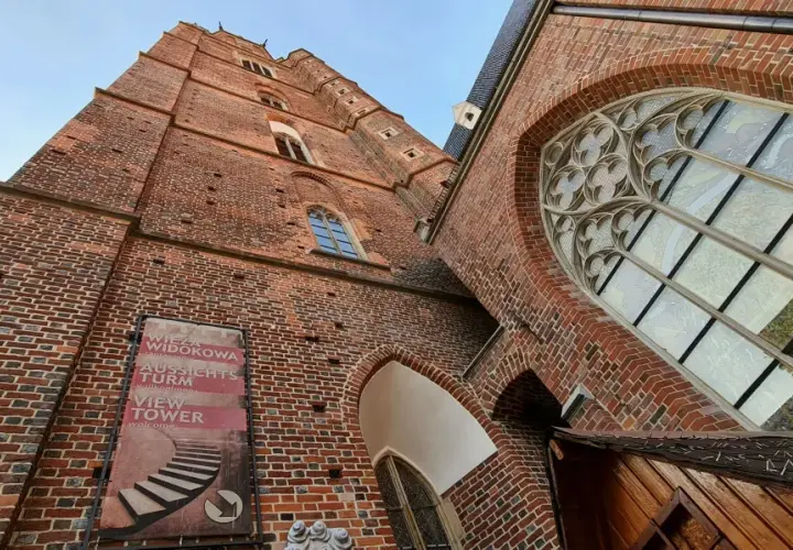 Wrocławski kościół garnizonowy z cegły, z widokiem na wieżę widokową.
