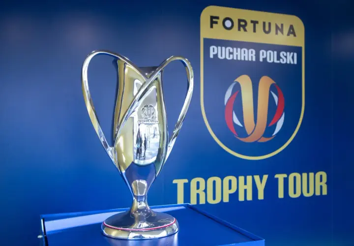 Błyszczący puchar Fortuna Pucharu Polski na tle niebieskiej ściany z logo i napisem "Trophy Tour".