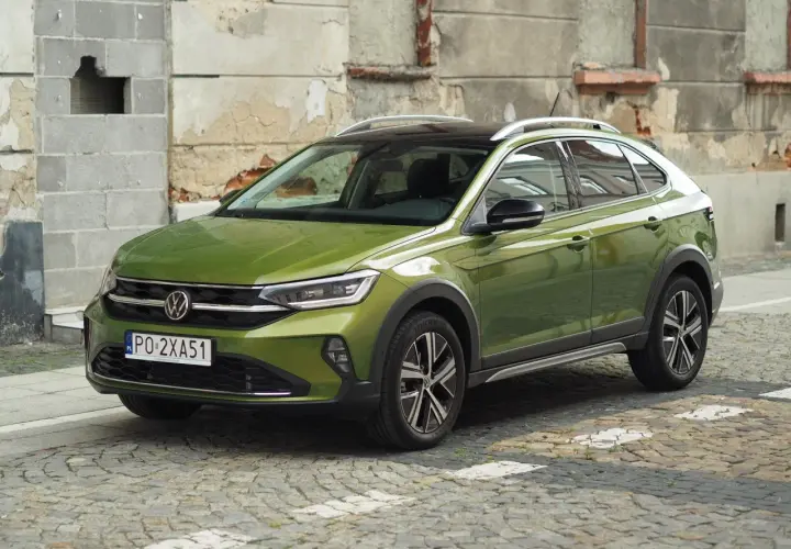 Zielony Volkswagen Taigo na brukowanej ulicy. Sprawdź atrakcyjną vw taigo cena i wybierz swój wymarzony samochód.