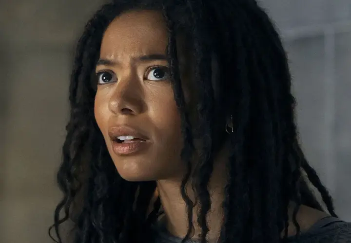 Gros plan sur le visage d'une jeune femme aux dreadlocks, l'air choqué. Elle pourrait être un personnage de gen v saison 3.