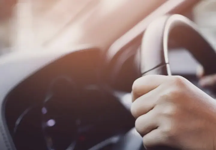 Manos al volante, sintiendo un extraño ruido al girar el volante a baja velocidad.