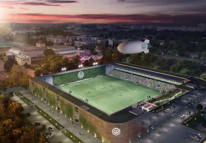 Nowoczesny stadion Warty Poznań z zielonymi fasadami i sterowcem nad boiskiem.