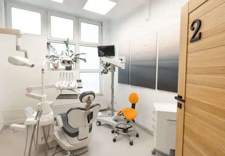 Nowoczesny gabinet stomatologiczny z fotelem, mikroskopem i drzwiami z numerem 2.