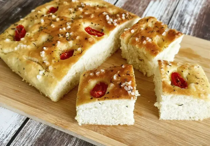 Oryginalna włoska focaccia przepis. Chrupiąca skórka, puszyste wnętrze, pomidorki i zioła. Idealna na przekąskę.