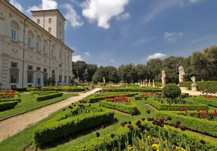 Jardins à la française de la Villa Borghese, avec des parterres de tulipes rouges et noires, des haies taillées et des statues.