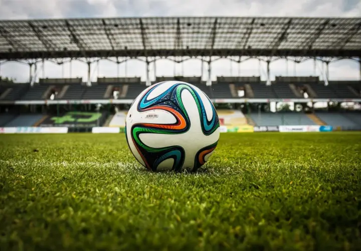 Piłka na murawie stadionu, gotowa do gry. Czekamy na sygnał, by dowiedzieć się, ile trwa dogrywka w piłce nożnej.