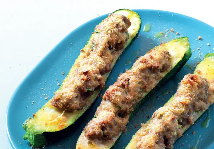 Zucchine ripiene velocissime, dorate e croccanti, servite su un piatto blu. Un piatto semplice e gustoso.