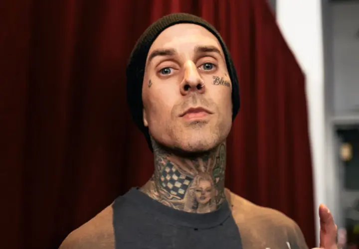 Travis Baker w czarnej czapce beanie, z tatuażami na twarzy i szyi, w tym wizerunkiem Marilyn Monroe.