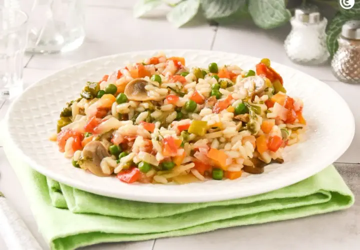 Un cremoso risotto de verduras con guisantes, champiñones y tomate.