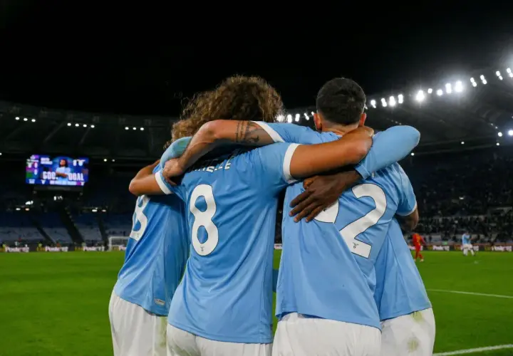 Piłkarze Lazio świętują bramkę w meczu z A.C. Milan. Stadion wypełniony kibicami, na tablicy wyników "GOAL".