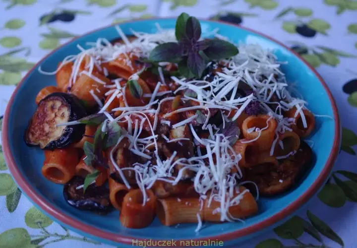 Pyszne danie pasta alla norma z makaronem rigatoni, bakłażanem w sosie pomidorowym i startym serem.