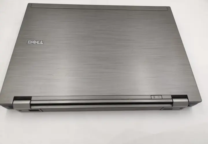 Zamknięty laptop Dell Latitude E6410, z widocznym logo Dell i przyciskami zasilania. Idealny do sprawdzenia dell latitude e6410 specyfikacja.