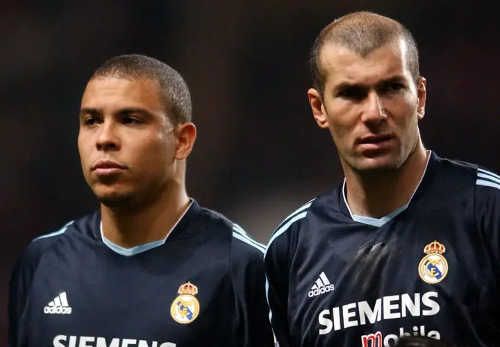 Ronaldo i Zidane, dwaj legendarni galacticos Realu Madryt, w ciemnych strojach meczowych.