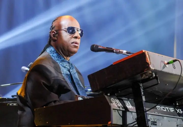 Niewidomy piosenkarz Stevie Wonder gra na keyboardzie Yamaha podczas koncertu.