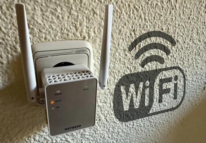 Extensor de red **wireless WAN** enchufado a la pared, con un símbolo de Wi-Fi al lado.