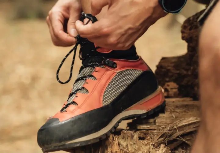 Lacing up sturdy resole hiking boots for an adventure. The orange and black design promises grip and support on any trail.