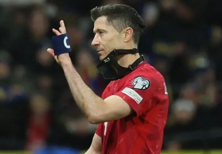 Robert Lewandowski, kapitan kadry, w czerwonej koszulce z opaską "C" na ręce i maską RL9 na twarzy.