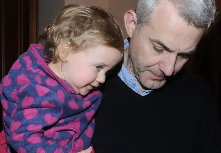 Hubert Urbański z córką, która przytula się do niego w bluzie w serduszka.