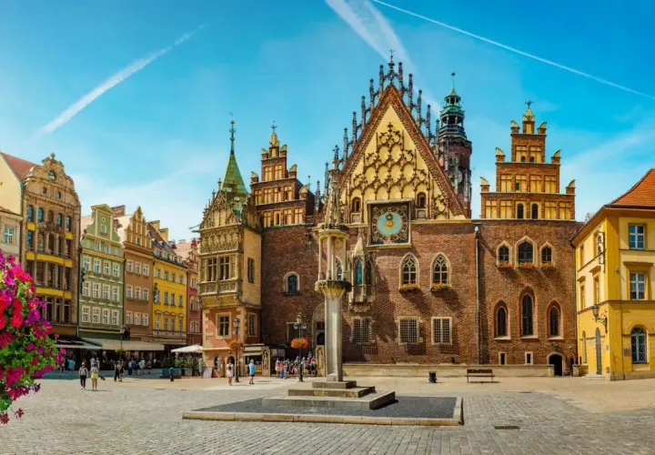 Rynek we Wrocławiu, idealne miejsce na city break z Wrocławia. Kolorowe kamienice, zabytkowy ratusz i kwitnące kwiaty tworzą malowniczy widok.