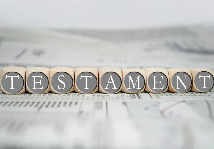 Drewniane klocki z literami tworzą słowo "TESTAMENT", symbolizując prawo dziedziczenia i testament.