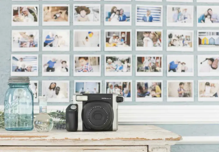 Instax aparat i ściana pełna wspomnień. To idealne miejsce, by zacząć naukę podstaw fotografii i uwieczniać ważne chwile.