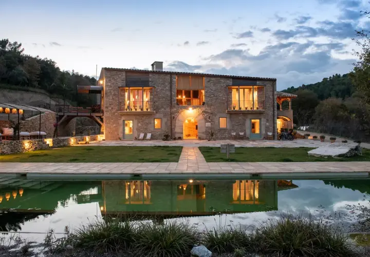 Casa rural en Pinell de Solsonès, con piscina y reflejos de luces cálidas.