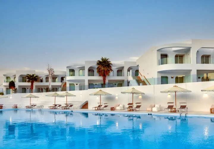 Basen i białe budynki z palmami w Meraki Resort Sharm El Sheikh. Idealne miejsce na relaks.