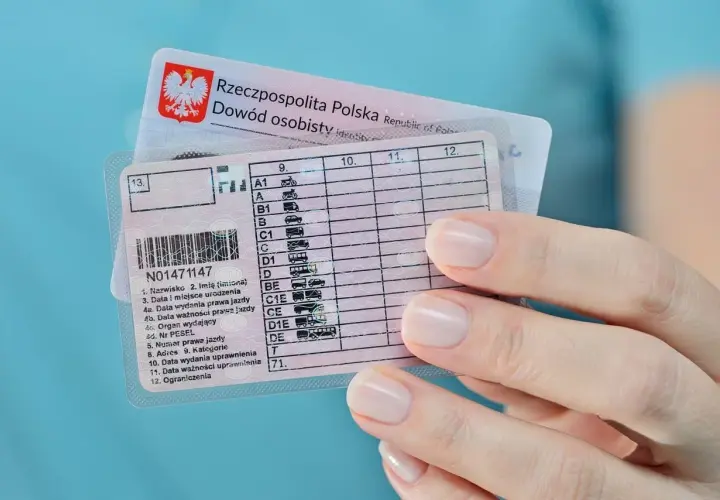 Dłoń trzyma polskie prawo jazdy, widoczna jest data ważności uprawnienia.