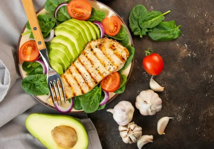 Pechuga de pollo a la parrilla con aguacate, espinacas y tomate. Ideal para una dieta antiinflamatoria menopausia.