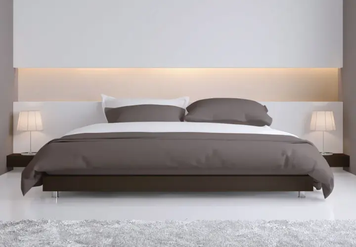 Elegante camera da letto con letto moderno e testata letto cartongesso illuminata, comodini con lampade e tappeto soffice.