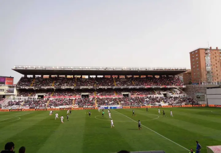 Mecz na madryckim stadionie. Piłkarze biegają po zielonej murawie, a trybuny wypełniają kibice.