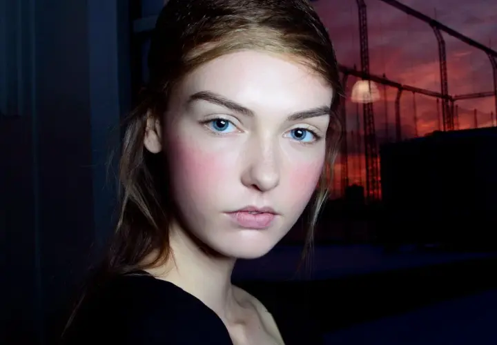 Ragazza con blush rosato sulle guance, un esempio di come scegliere il colore del blush per un look naturale.