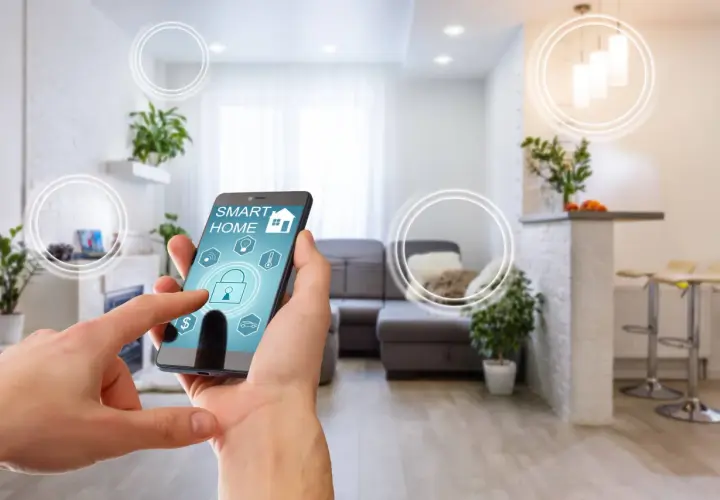 Dłoń steruje aplikacją "Smart Home" na telefonie, symbolizującą inteligentne życie i komfortowe mieszkanie.