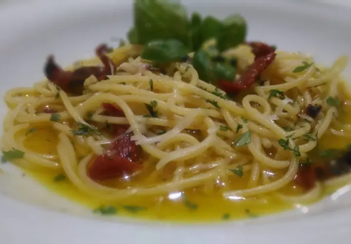 Spaghetti alla carrettiera conditi con pomodori secchi, aglio, peperoncino e basilico fresco, un piatto semplice ma gustoso.