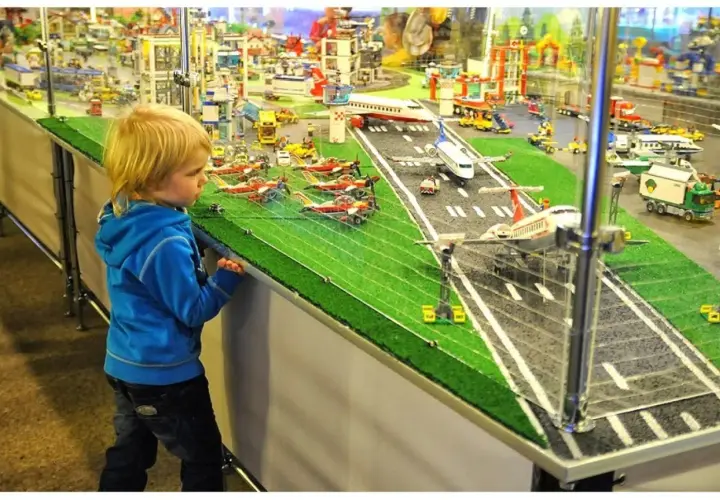 Chłopiec zafascynowany lotniskiem z klocków LEGO w Muzeum Klocków LEGO Kraków.