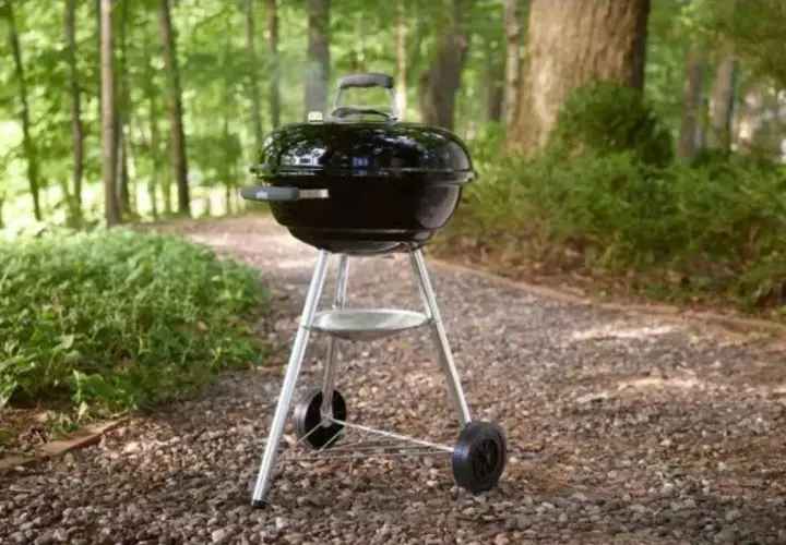 Barbecue noir avec couvercle, prêt pour un repas en plein air. Apprenez comment utiliser un barbecue avec couvercle pour des grillades parfaites.