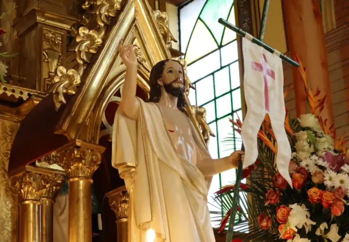 Figura Jezusa z chorągwią z krzyżem, otoczona złotymi zdobieniami i kwiatami. Symbolizuje zwycięstwo i nadzieję, przypominając o tym, ile trwaja rezurekcje.