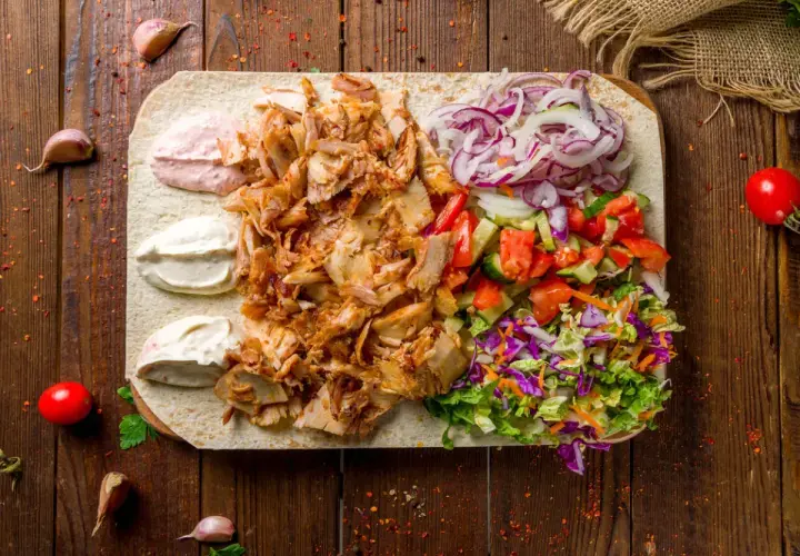 Pyszna shoarma z kurczaka na placku z warzywami i sosami. Idealna na szybki posiłek.