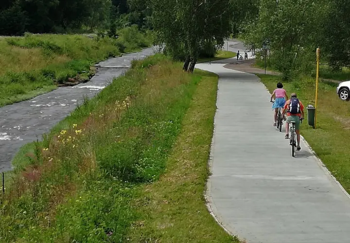 Rowerzyści na ścieżce wzdłuż potoku. Velo Krynica zaprasza do aktywnego wypoczynku na łonie natury.