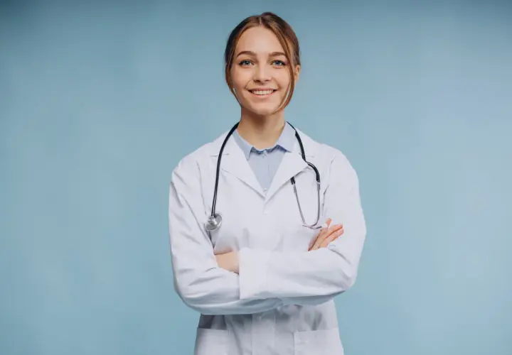 Uśmiechnięta lekarka w białym kitlu ze stetoskopem, zastanawia się, ile zarabia psychiatra.