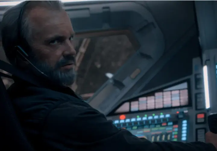 Un homme barbu, casque sur les oreilles, aux commandes d'un vaisseau spatial. L'avenir de l'humanité est en jeu dans For All Mankind saison 5.